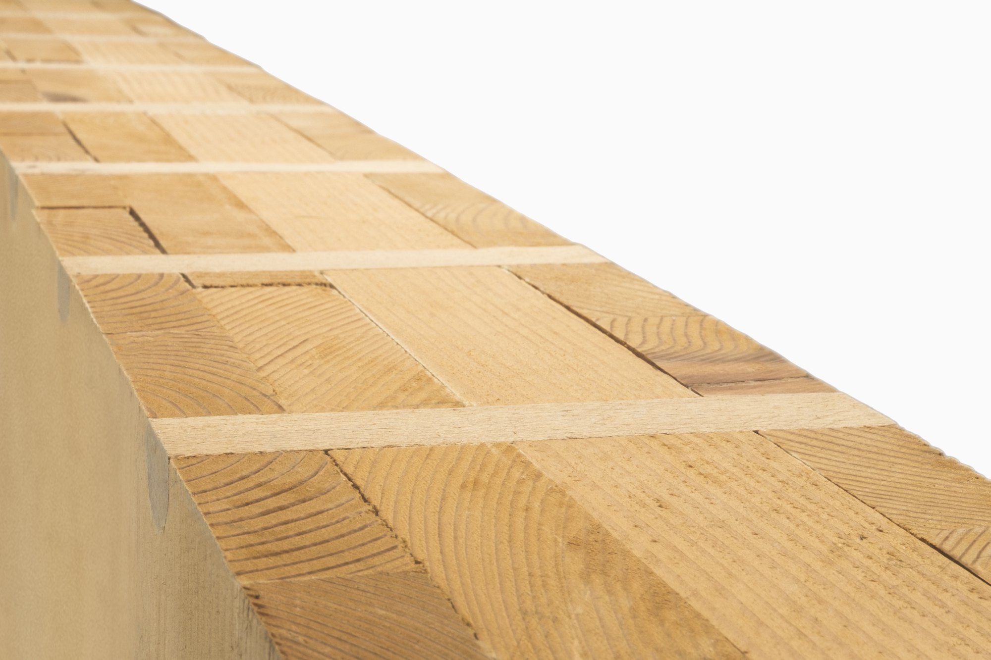 Nahaufnahme einer Holz100-Wand: kreuzweise geschichtete Holzlagen, verbunden mit Buchenholzdübeln